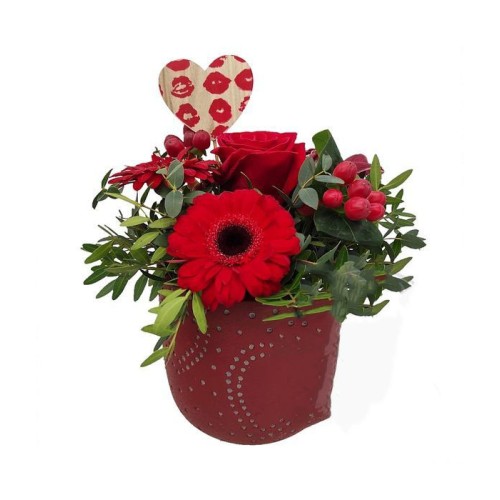 Flower arrangement in red ceramic pot with hearts