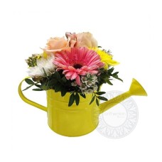 Yellow watering can with fresh flowers