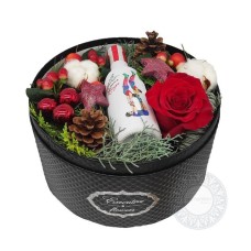 Gift box with xmas decoration and a small bottle of wine