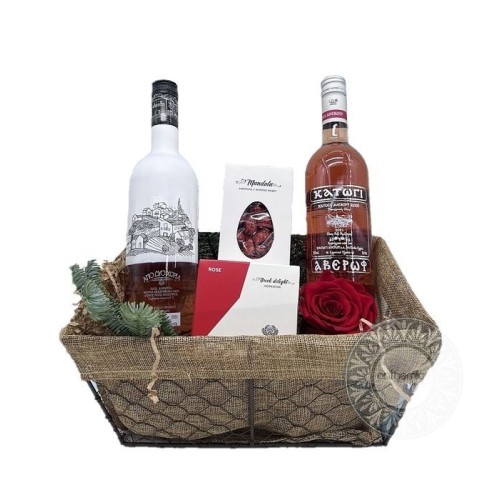 Basket with rosÃ© wines and sweet treats