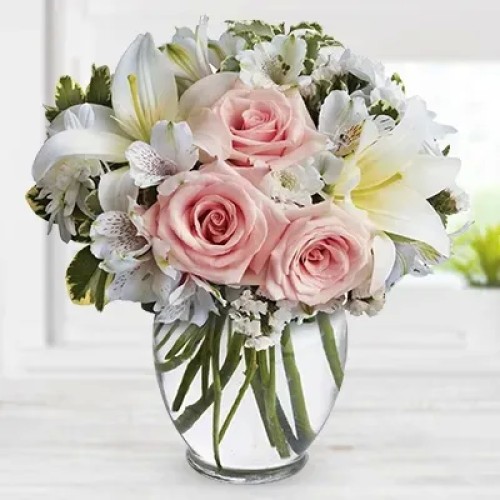 Arrive In Style (4 stems of Peach roses with 2 stems of white lilies, 2 stems of white alstroemeria and 2 stems of chrysanthemums in a cube Glass vase. (one sided round arrangement))