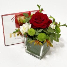 Flower arrangement in a glass vase and Merci candy box