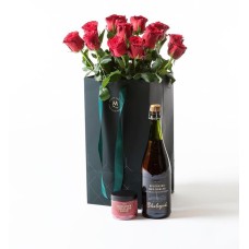 Red roses in a gift bag with bubbles and chocolate