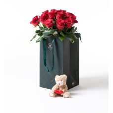 15 red roses in a gift bag with teddy bear