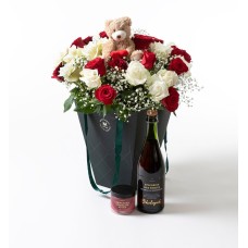 Red and white rose bouquet in gift bag with bubbles and teddy bear