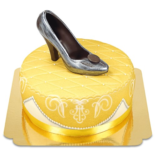Golden deluxe cake with chocolate shoe and ribbon